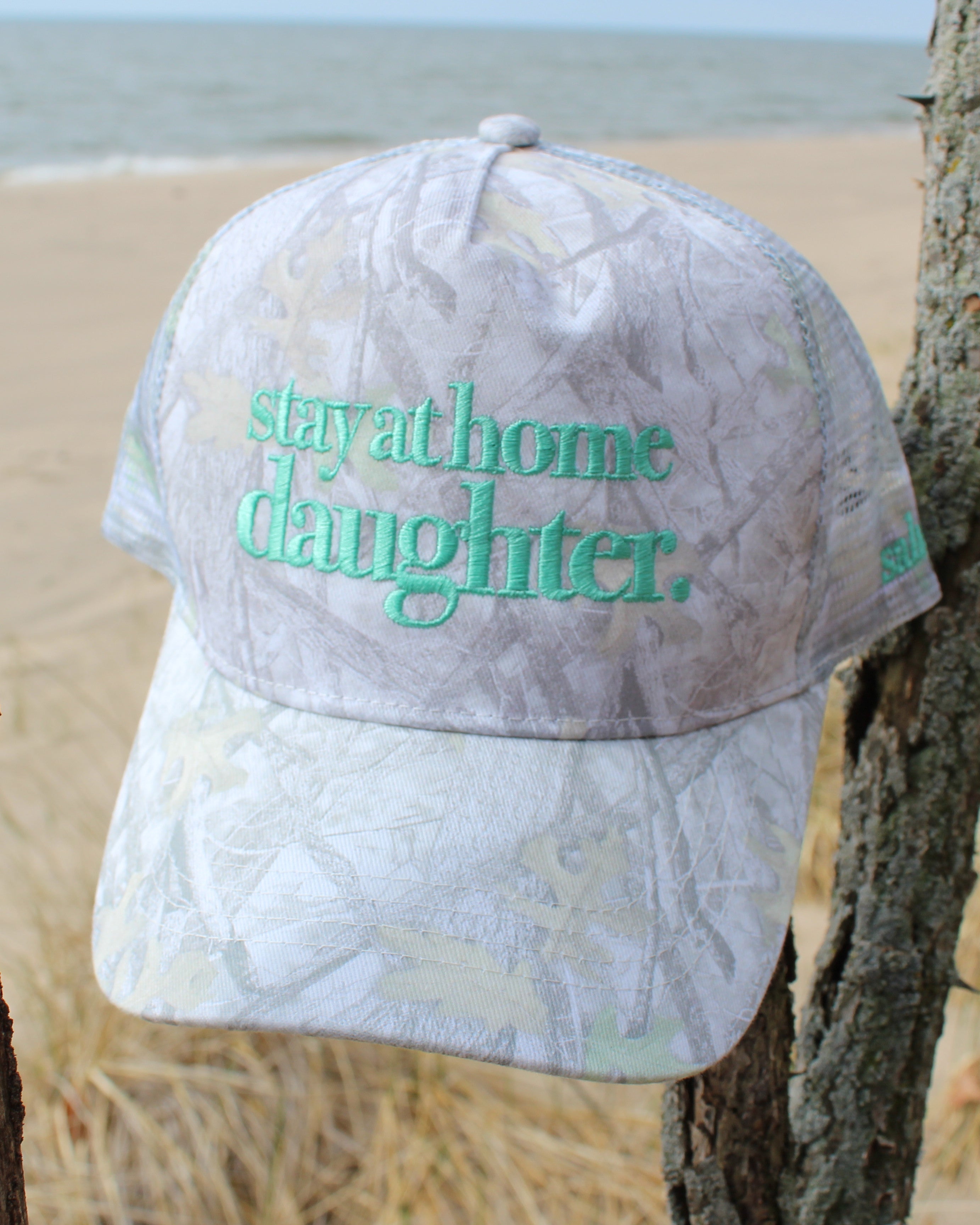 Cap with stay at home daughter text on a beach background