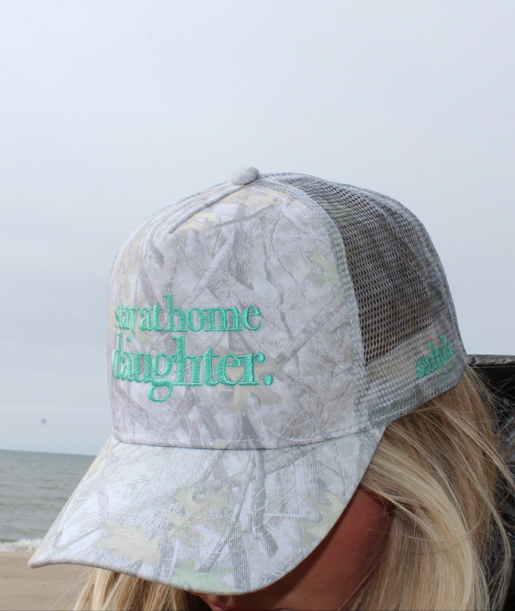 girl wearing stay at home daughter hat at the beach
