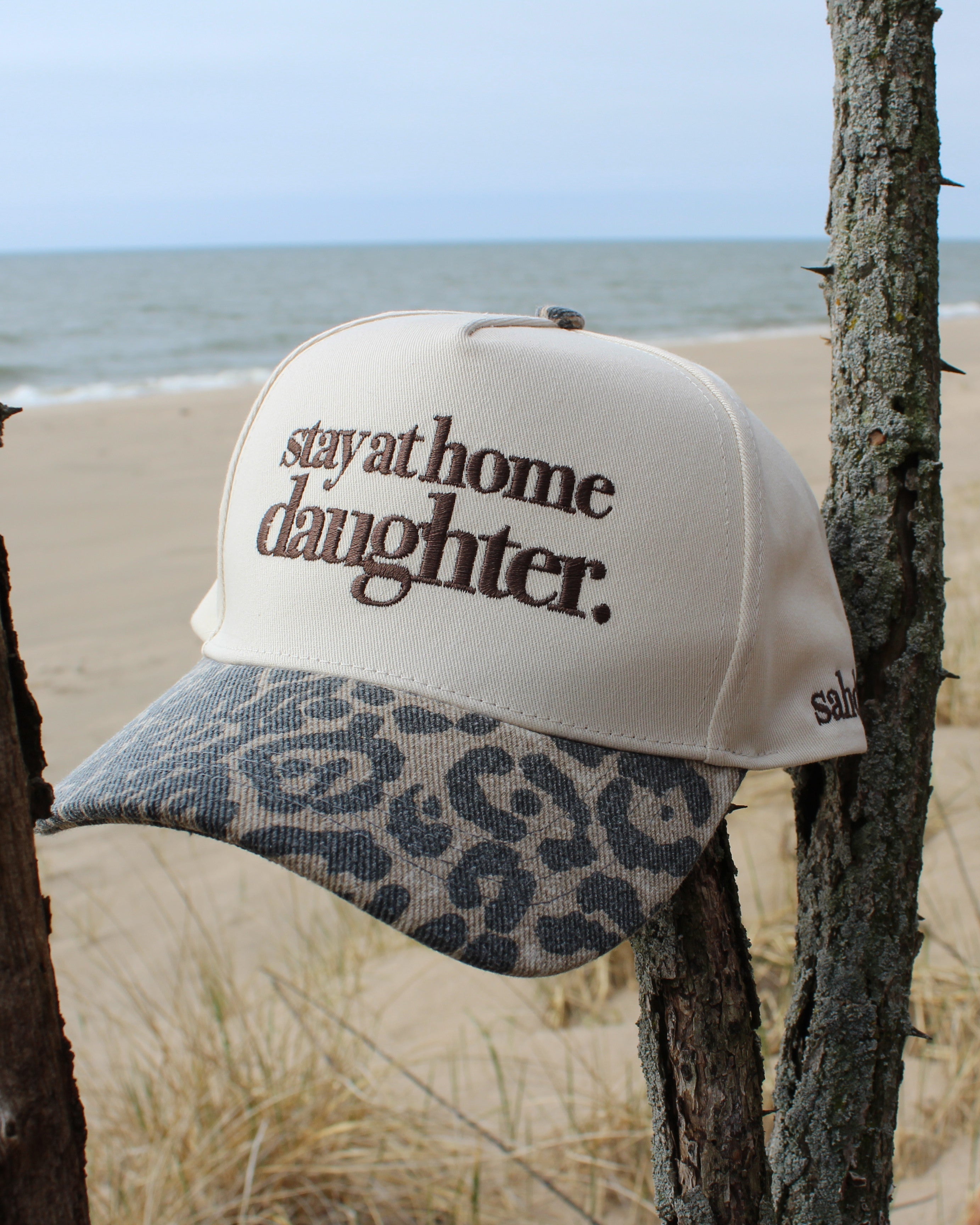Cheetah hat with 'stay at home daughter' text on a beach setting