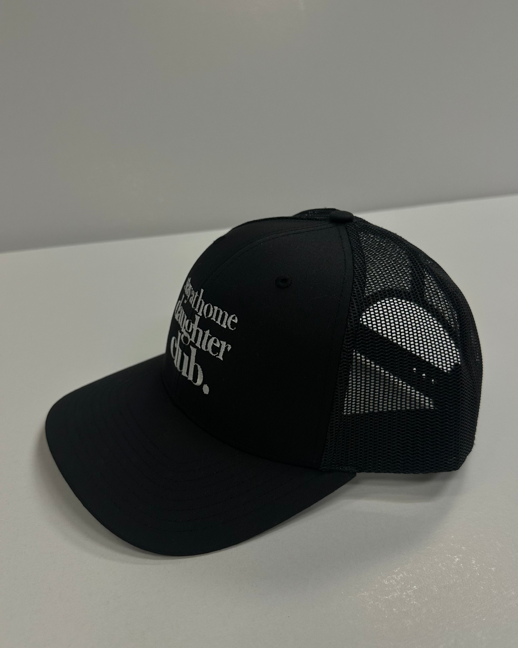 Black trucker hat with white text
